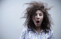 Image of a woman with messy hair, yawning