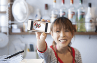 Image of cafe owner with video on phone screen