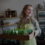Smiling shop owner holding plants