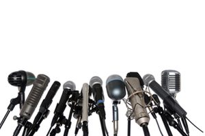 Various microphones aligned at press conference isolated over a white background