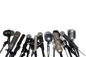 Various microphones aligned at press conference isolated over a white background