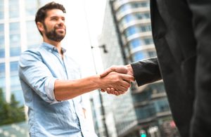 Human versus corporate - business handshake