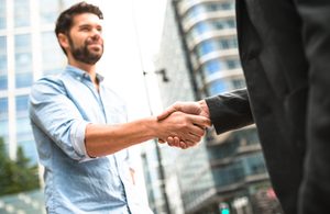 Human versus corporate - business handshake