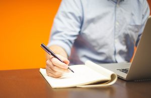 man writing in a notebook