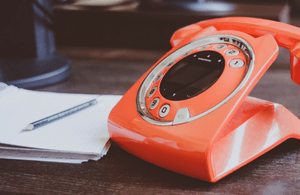 Red phone next to a notepad