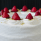 Delicious white cake with strawberries, cream and a pistachio crumb