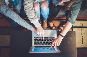 Group of people looking over laptop