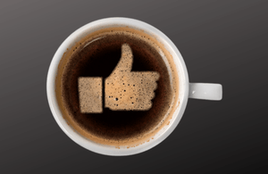 Cup of coffee with a like symbol on the surface