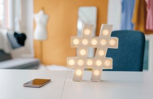 Illuminated hashtag sign on table in fashion studio