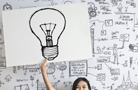 Girl holding up a light bulb sign