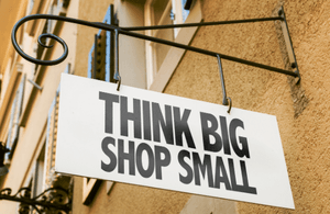 A shop sign saying "Think big, shop small"