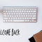 Keyboard on a desk with a note saying welcome back
