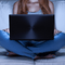 Woman sitting in the dark with a laptop